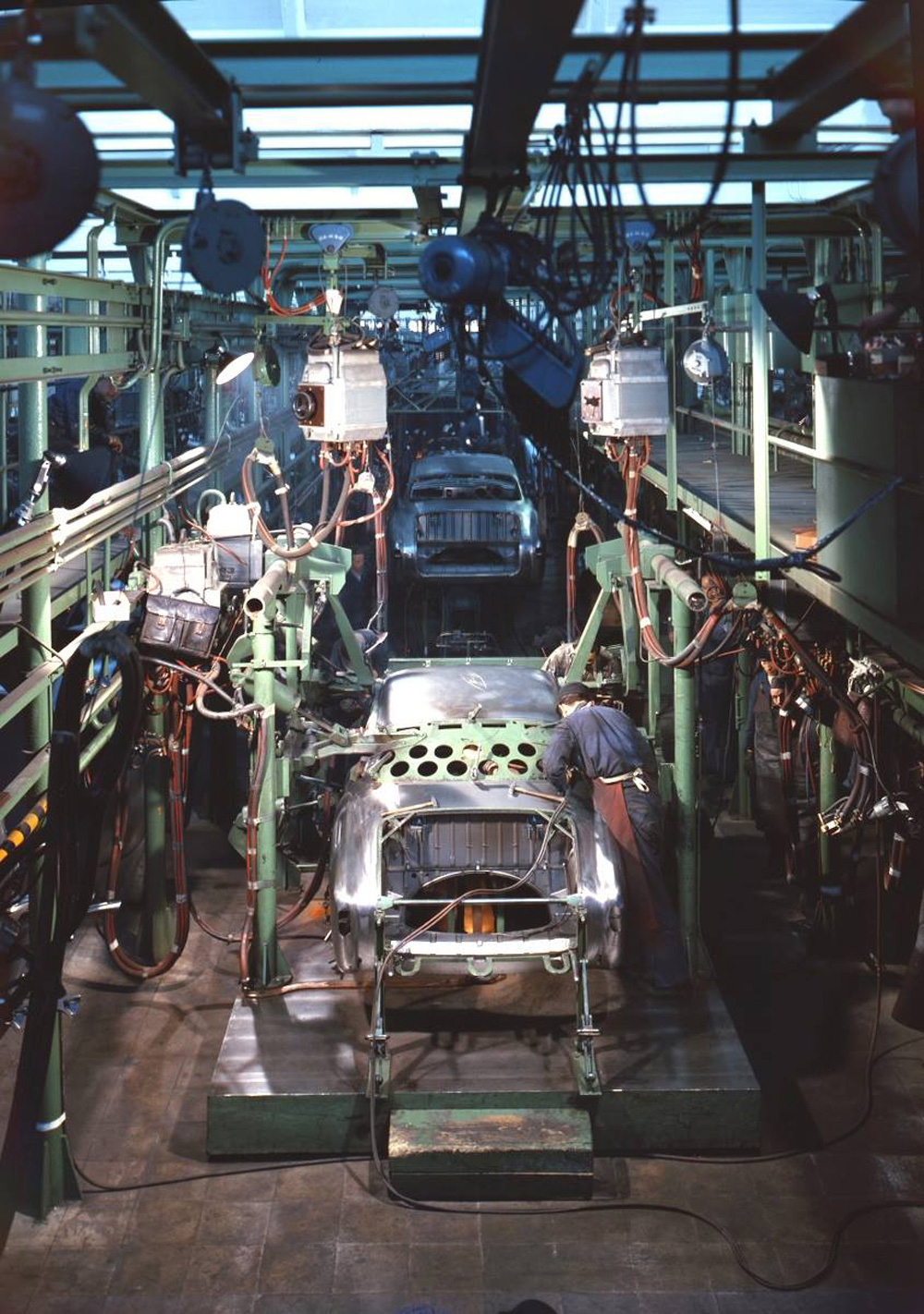 newly painted Type 1 bodyshells moving slowly toward the fitting out and trim lines in the final assembly hall at Wolfsburg
