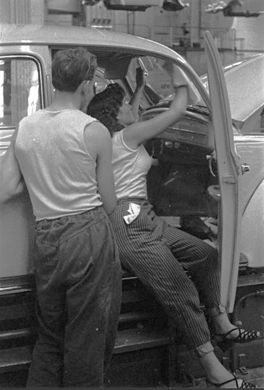 A 
        casually dressed line worker on the body fitting out line